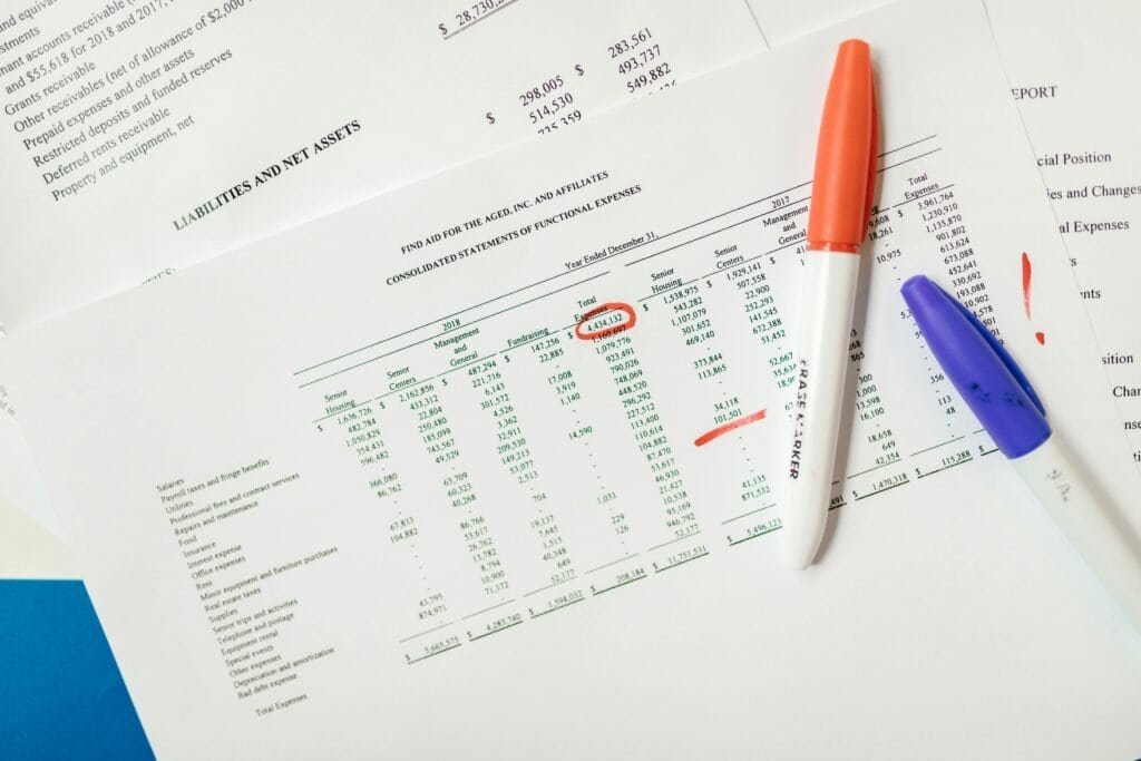 Close-up of financial documents with highlighted figures and marker pens.