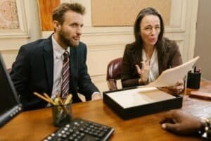 Lawyers discussing legal documents in a professional office setting.